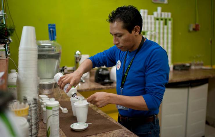 Edgar Montalban mixes a drink for a customer at his Herbalife storefront in the Corona area of Queens.
